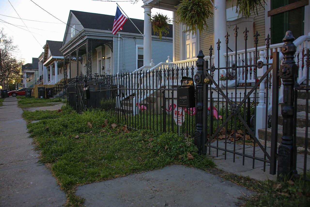Black wrought-iron style front fence and gate along a residential footpath