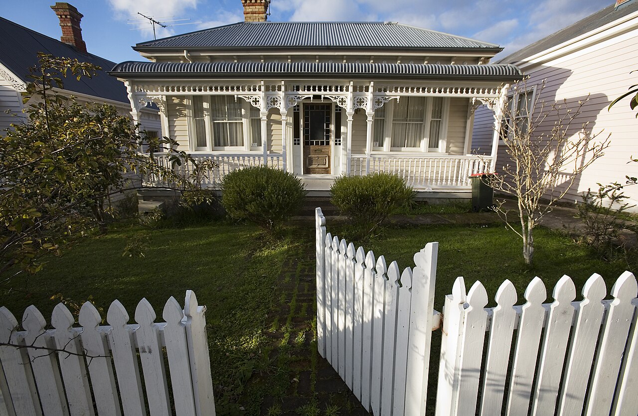 White timber picket fence and gate in front of a classic New Zealand villa